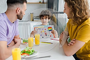 Kid holding picture with lgbt flag