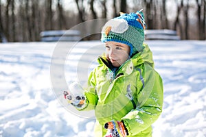 Kid holding a snowball in his hand