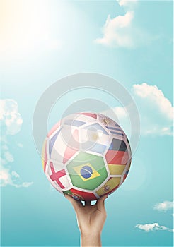 Kid holding a soccer ball with world flags against a blue sky background- concept of competition