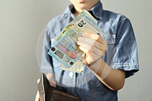 Kid holds euro banknotes and black wallet in his hand, concept of pocket money, theft, shopping