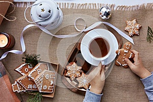 Kid holds homemade Christmas gingerbread cookies and cocoa. Atmoshperic winter decorations with hot drink. Home coziness photo