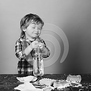 Kid holds spray and spraying water out of spray bottle.