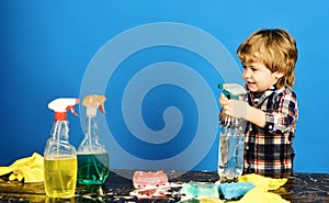 Kid holds spray and spraying water out of spray bottle.