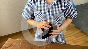 Kid holds a wallet and searches with his fingers, the concept of pocket money, theft, shopping