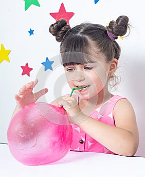 Kid inflates a big bubble from slime.