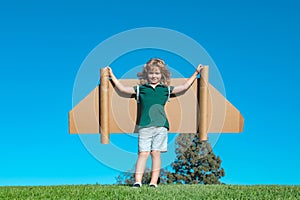 Kid with jet pack superhero. Child pilot against summer sky background. Boy with paper plane flight, toy airplane with