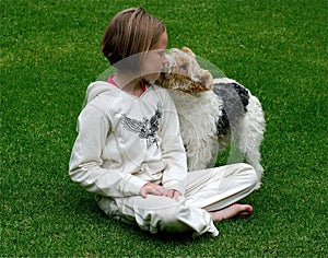 Kid kissing her puppy