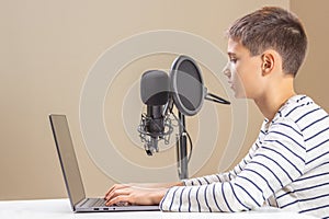 Kid with laptop computer talking into microphone. Techology, online learning, remote education, distance learning at