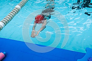 Kid learn how to swim in swimming class