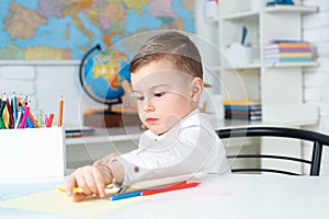 Kid is learning in class on background of blackboard. Education. Home schooler. Cute little boy studying. Children home