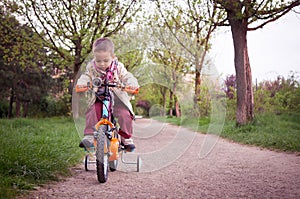 Kid learning to ride the bicycle in the park