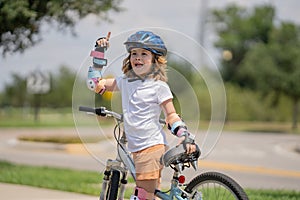 Kid learning to ride bike. Child riding bicycle. Little kid boy in helmet on bicycle along bikeway. Happy cute little