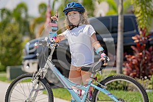 Kid learning to ride bike. Child riding bicycle. Little kid boy in helmet on bicycle along bikeway. Happy cute little