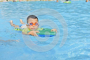 Kid learning to swim in summer
