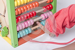 Kid learns on mathematic concept using colorful counting beads.