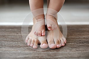 The kid learns to take first steps with the help of his mother, close-up