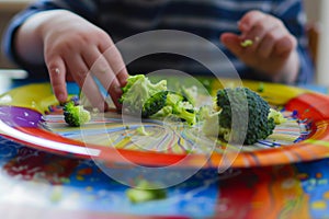 kid leaving behind uneaten broccoli on a colorful dinner plate