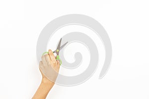 Kid left hand holding scissors over white background. Top view, copy space for text. Left Handers Day