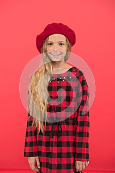 Kid little cute girl with long hair posing in hat red background. Fashionable beret accessory for female. How to wear