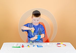 Kid little doctor sit table with stethoscope and medical tools. Medicine concept. Medical examination. Medical education