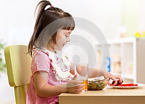 Kid little girl eating healthy vegetables