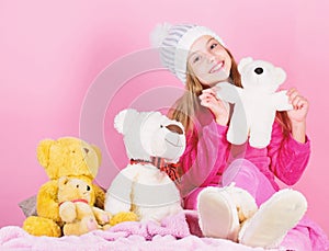 Kid little girl play with soft toy teddy bear on pink background. Toy every child dreaming. Happy childhood concept