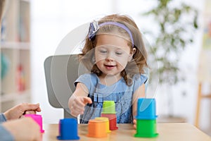 Kid little girl playing with toys indoors