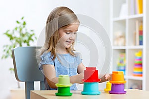 Kid little girl playing with toys indoors