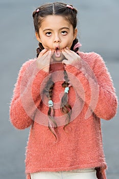 Kid with long braided hair make bored grimace face. So boring. Bored girl going crazy. Play with facial expressions