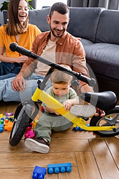 Kid looking at bike near parents