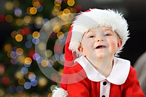 Kid looking at camera in christmas wearing santa disguise