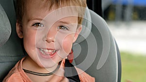 Child smiling while sitting in car seat