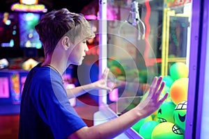 Kid Looking at the Toy Balls in an Arcade Claw Prize Machine Game