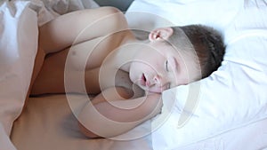 Kid lying on bed, Sleepy child waking up the morning in bed room with morning