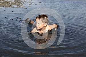 Kid lying in the black mud