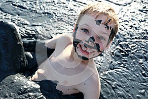 Kid lying in healing mud