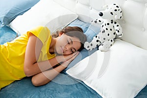 Kid lying and sleeping on bed with toy. Child teen sleeps in the bed. Sleeper, napping concept. Sleeping and dreaming