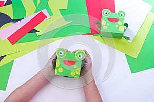 Kid makes a frog out of paper