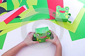 Kid makes a frog out of paper