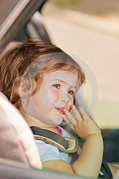 Kid making faces sitting in car safety seat