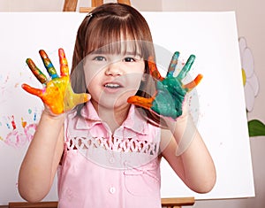 Kid making handprints with paint.