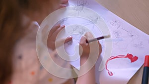 Kid with mom drawing on paper, mother helping daughter with homework, sitting at table, family concept