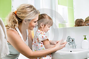 Kid with mom washing hands