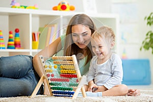 Kid and mother playing with abacus