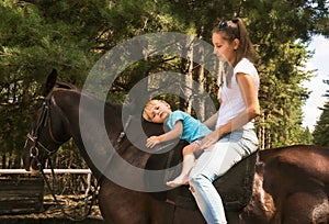 Kid with mum drive on horse top