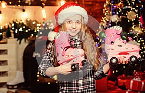 Kid near christmas tree hold roller skates. Girl satisfied christmas gift. Christmas gift she dreamed about. Best gift