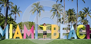 Kid near Miami Beach sign. Kid enjoy summer vacation holiday. Travel, childhood happiness concept. Summer Holiday at