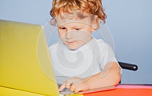 Kid with a notebook. Closeup portrait of clever child boy pupil with laptop. Child from elementary school. Cheerful