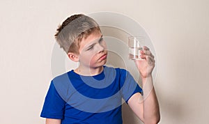 Kid observing a half full or half empty glass of water.