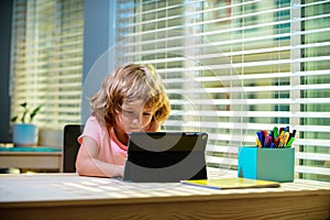 Kid at online school, home schooling. On-line remote learning. Child pupil learning language or math, online, using